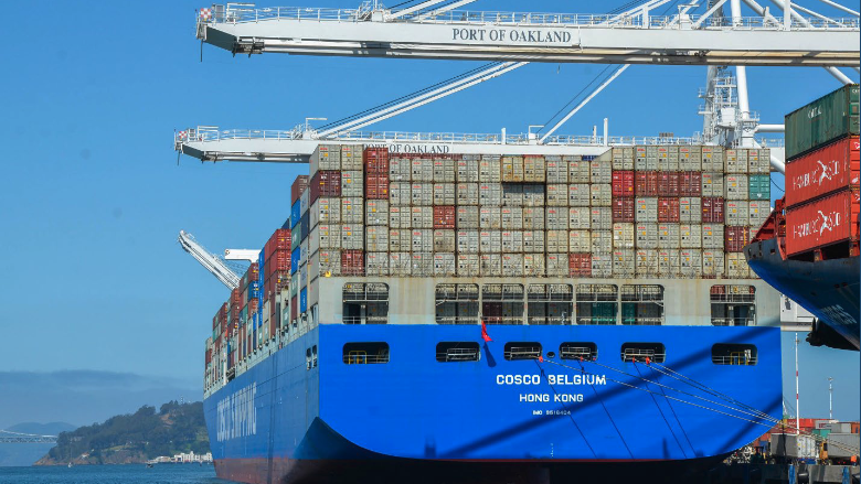A megaship loaded with thousands of shipping containers docks at the Port of Oakland.
