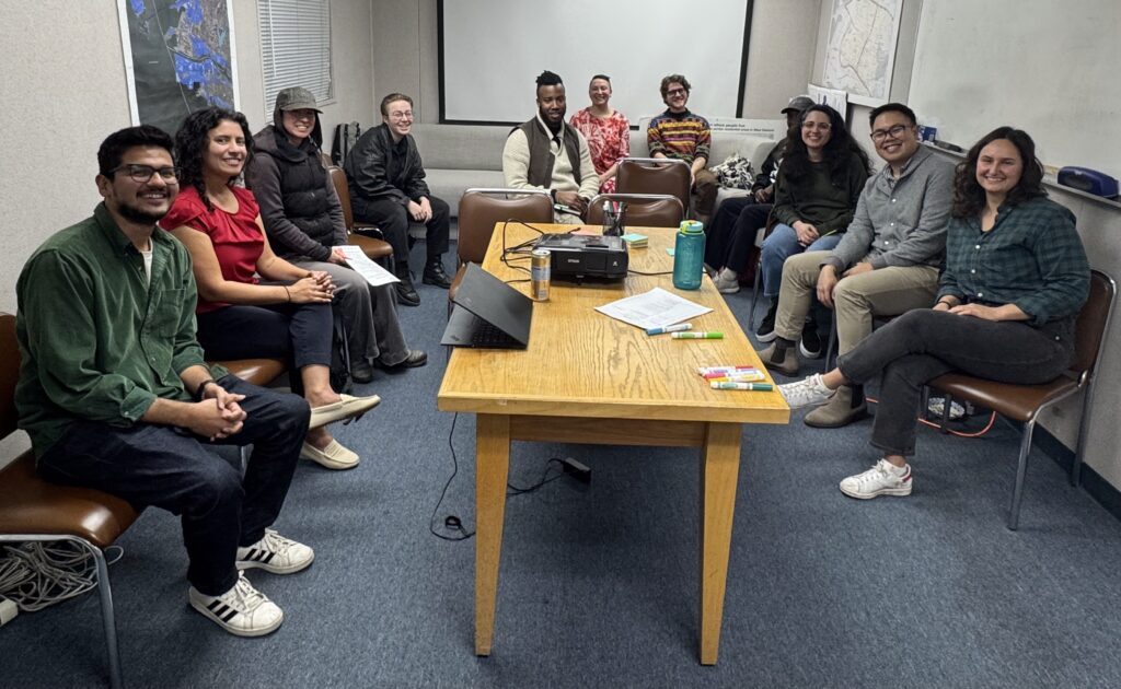 People sit around a table in the WOEIP office